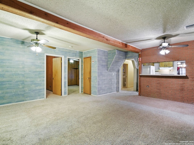 carpeted spare room featuring beamed ceiling and a textured ceiling