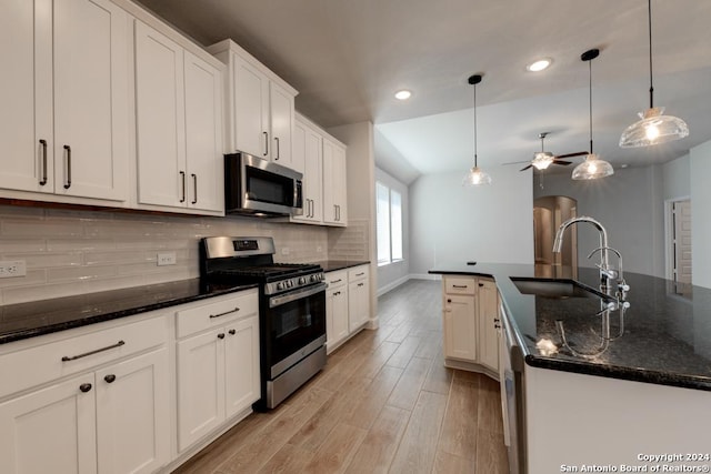 kitchen featuring white cabinetry, sink, ceiling fan, stainless steel appliances, and decorative light fixtures
