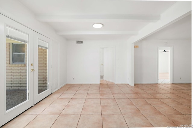 unfurnished room featuring beamed ceiling, ceiling fan, and light tile patterned floors