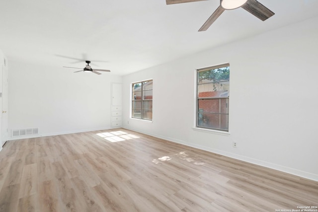 empty room with ceiling fan and light hardwood / wood-style floors