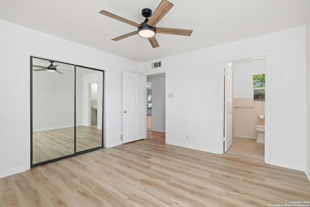 unfurnished bedroom featuring ensuite bath, ceiling fan, tile walls, light hardwood / wood-style floors, and a closet