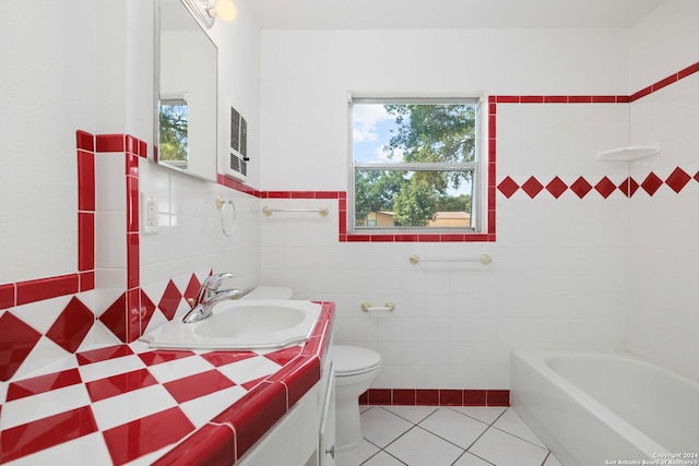 bathroom featuring a bathtub, vanity, tile patterned flooring, toilet, and tile walls