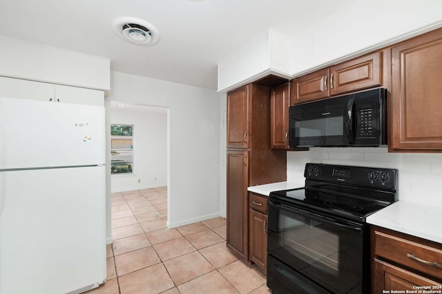 kitchen with black appliances, light tile patterned floors, and tasteful backsplash