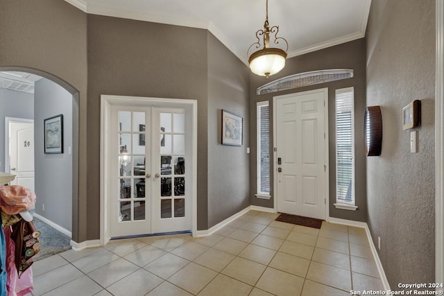 foyer with crown molding, french doors, and light tile patterned flooring