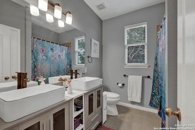 bathroom with tile patterned flooring, plenty of natural light, toilet, and vanity