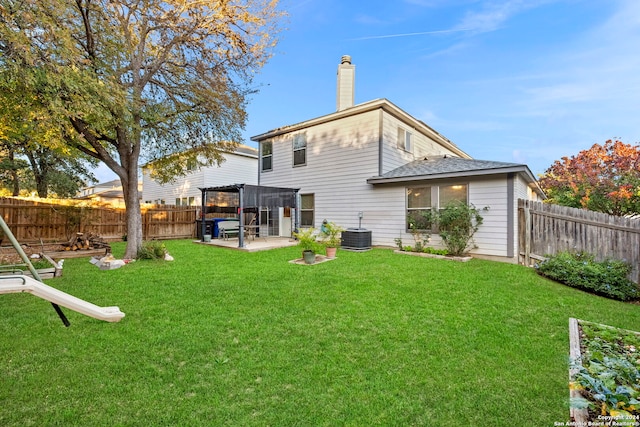 rear view of house with central air condition unit, a patio area, and a yard