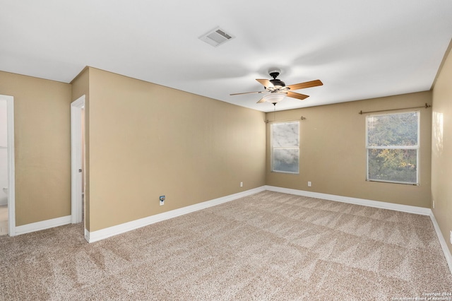 empty room featuring ceiling fan and carpet