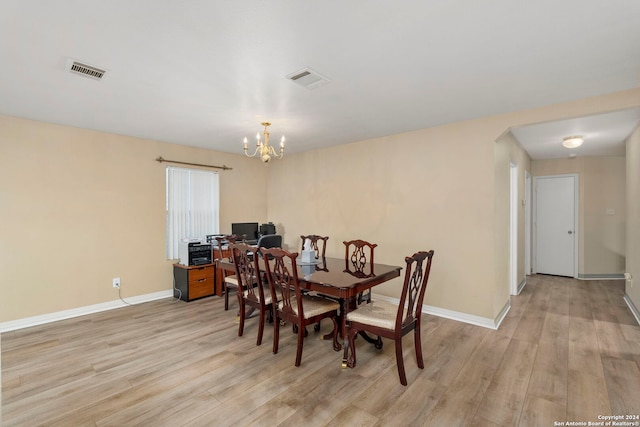 dining area featuring light hardwood / wood-style floors and an inviting chandelier