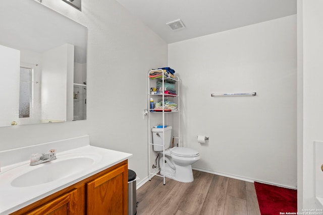 bathroom featuring hardwood / wood-style flooring, vanity, and toilet