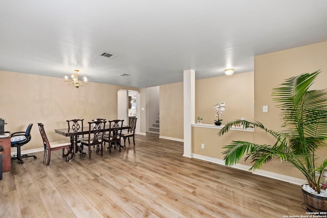 dining room featuring light wood-type flooring and a chandelier