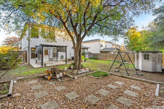 view of yard featuring a patio area, a playground, and a storage shed