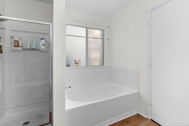 bathroom with hardwood / wood-style floors and independent shower and bath