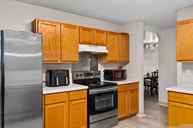 kitchen featuring a chandelier, stainless steel appliances, and light hardwood / wood-style floors