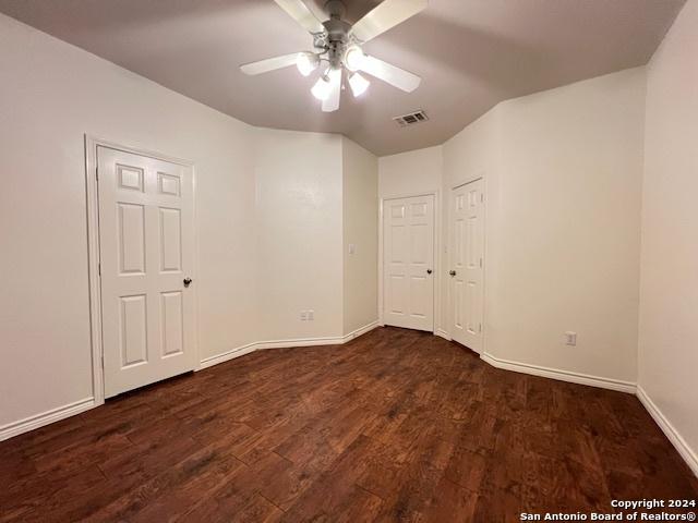 empty room with dark hardwood / wood-style floors and ceiling fan