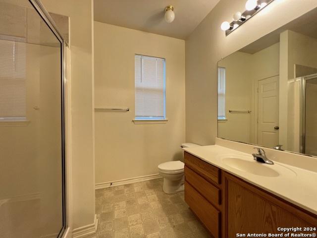 bathroom with vanity, toilet, and an enclosed shower