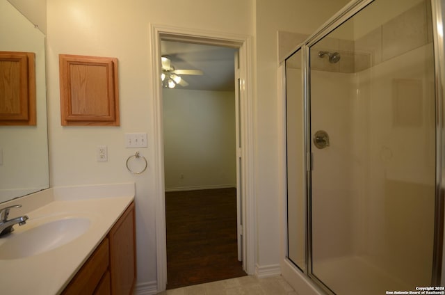 bathroom with vanity, hardwood / wood-style flooring, an enclosed shower, and ceiling fan