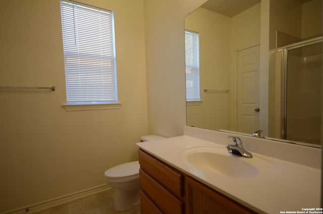 bathroom featuring walk in shower, vanity, a healthy amount of sunlight, and toilet