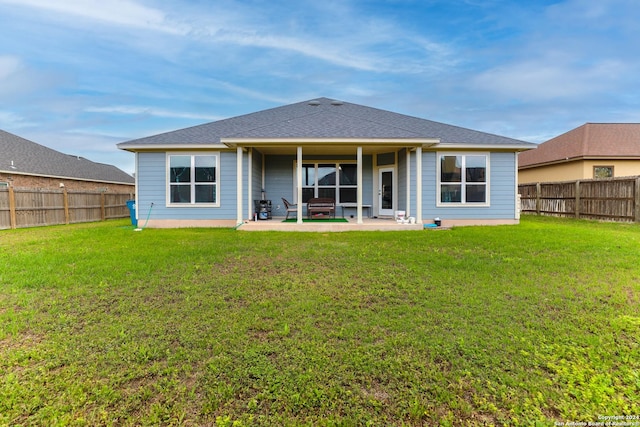 rear view of property featuring a patio and a lawn