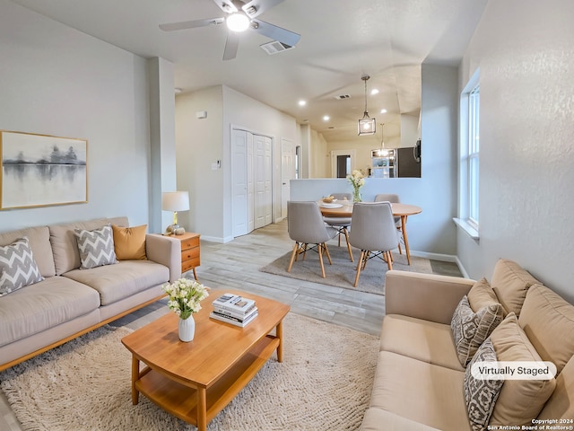 living room featuring light hardwood / wood-style floors and ceiling fan