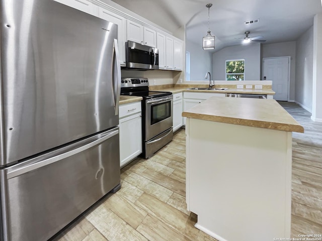 474 Wind Gust, New Braunfels, TX 78130 - kitchen featuring appliances with stainless steel finishes, a peninsula, light countertops, a center island, and white cabinets