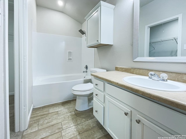 full bathroom featuring shower / bathing tub combination, vanity, vaulted ceiling, hardwood / wood-style flooring, and toilet