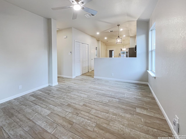 unfurnished living room featuring ceiling fan and light wood-type flooring