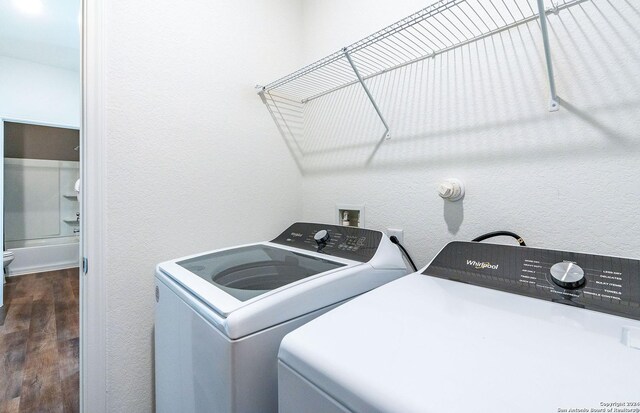 4076 Paddock Trl, Seguin, TX 78155 - laundry room with washing machine and clothes dryer, dark wood finished floors, and a textured wall