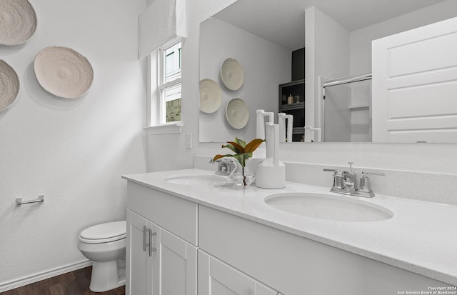 bathroom with vanity, hardwood / wood-style flooring, toilet, and a shower with shower door