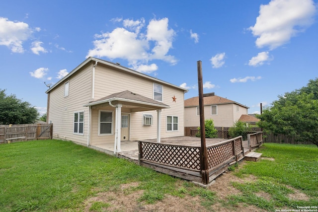 rear view of property featuring a wooden deck and a yard