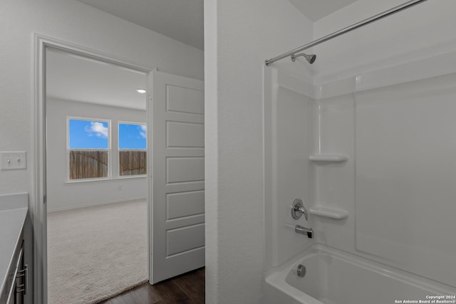 bathroom featuring hardwood / wood-style floors and washtub / shower combination