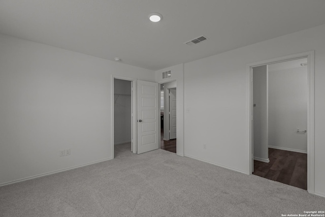 unfurnished bedroom with carpet flooring and a spacious closet