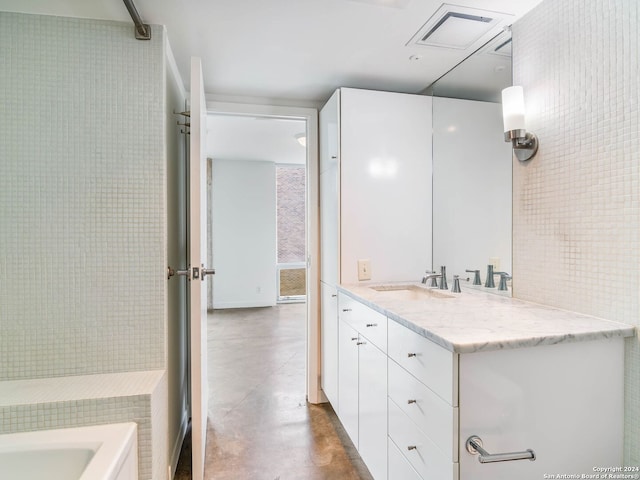 1115 S Alamo St Unit 2310, San Antonio, TX 78210 - full bathroom with concrete floors, vanity, a tub, and tile walls