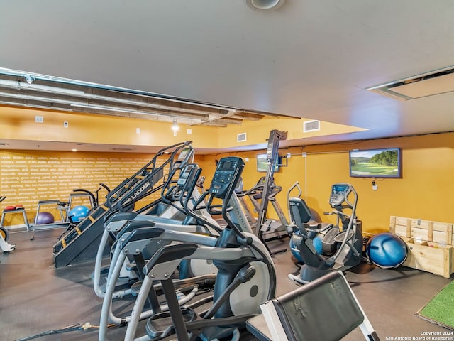 workout area featuring brick wall