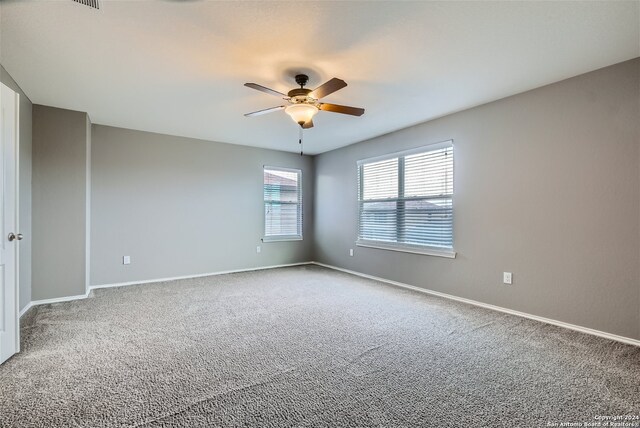 carpeted spare room featuring ceiling fan