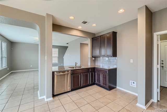 kitchen featuring dishwasher, light stone counters, dark brown cabinetry, and sink