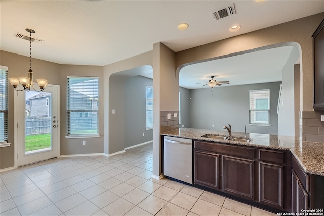 kitchen featuring dishwasher, sink, light stone countertops, and plenty of natural light