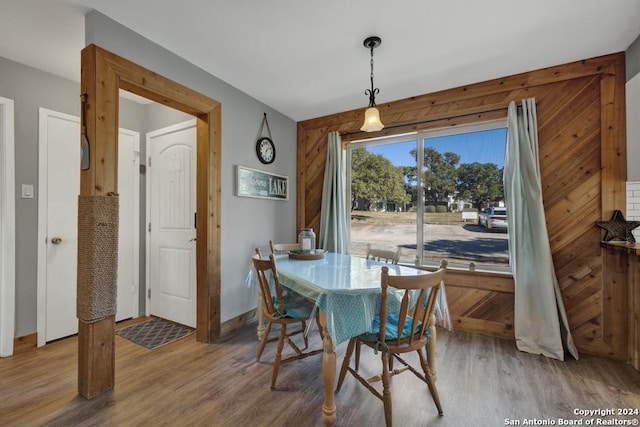 dining room featuring hardwood / wood-style flooring and wood walls