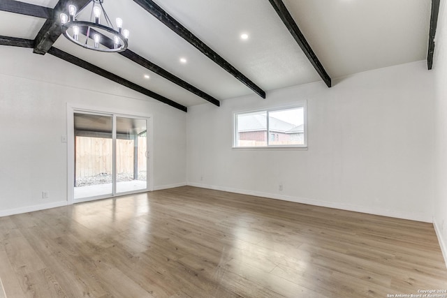 unfurnished room with a chandelier, lofted ceiling with beams, and light wood-type flooring