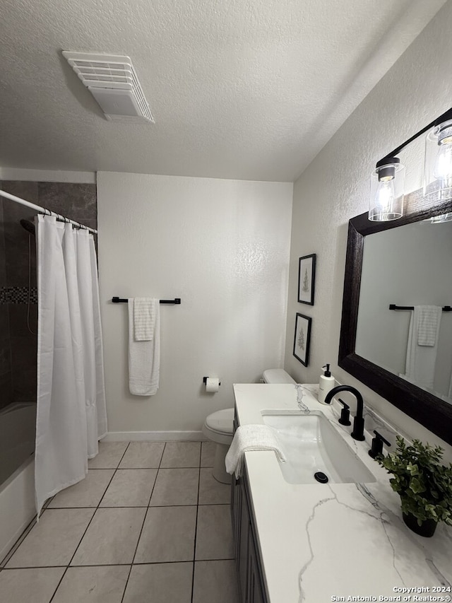 full bathroom with vanity, a textured ceiling, tile patterned floors, and shower / tub combo with curtain