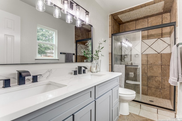 bathroom with tile patterned floors, vanity, toilet, and an enclosed shower