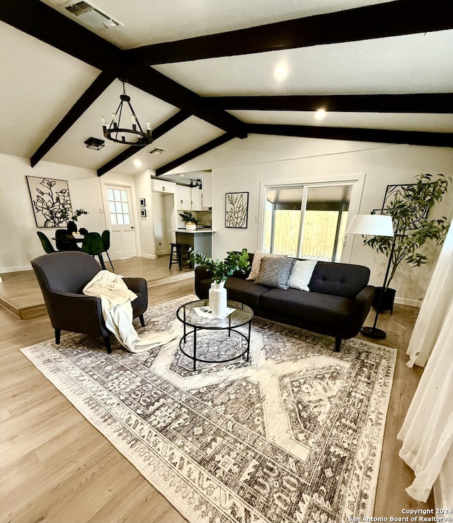 living room featuring vaulted ceiling with beams, hardwood / wood-style floors, and a healthy amount of sunlight