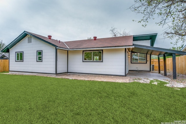 rear view of property with central air condition unit, a yard, and a carport