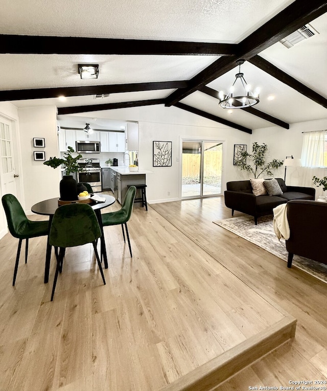 dining area featuring lofted ceiling with beams, a healthy amount of sunlight, and light hardwood / wood-style floors