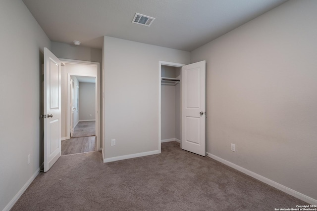 unfurnished bedroom featuring light colored carpet and a closet