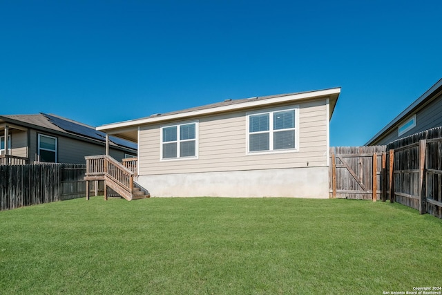 rear view of house featuring a lawn