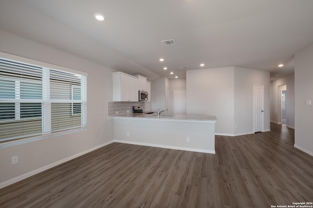 kitchen with dark wood-type flooring, white cabinets, sink, kitchen peninsula, and stainless steel appliances