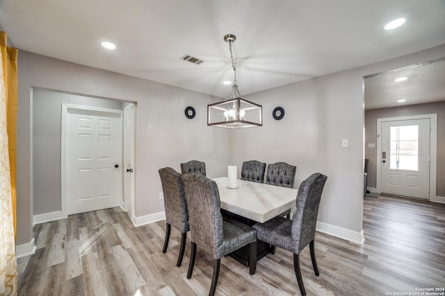 dining space featuring hardwood / wood-style floors and a notable chandelier