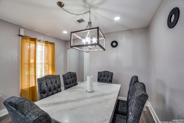 dining room with dark hardwood / wood-style floors and a chandelier