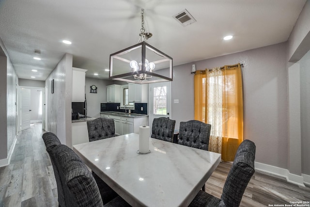 dining area with a chandelier, hardwood / wood-style flooring, and sink