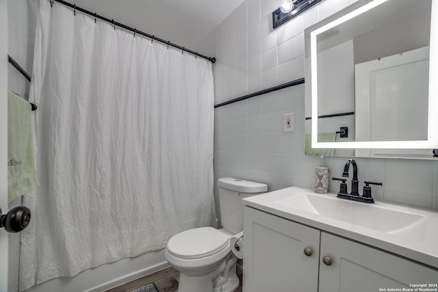 full bathroom with tile walls, wood-type flooring, toilet, vanity, and shower / tub combo